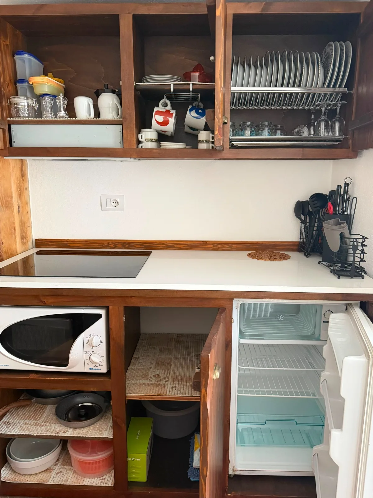 Cucina con stoviglie, microonde e frigorifero